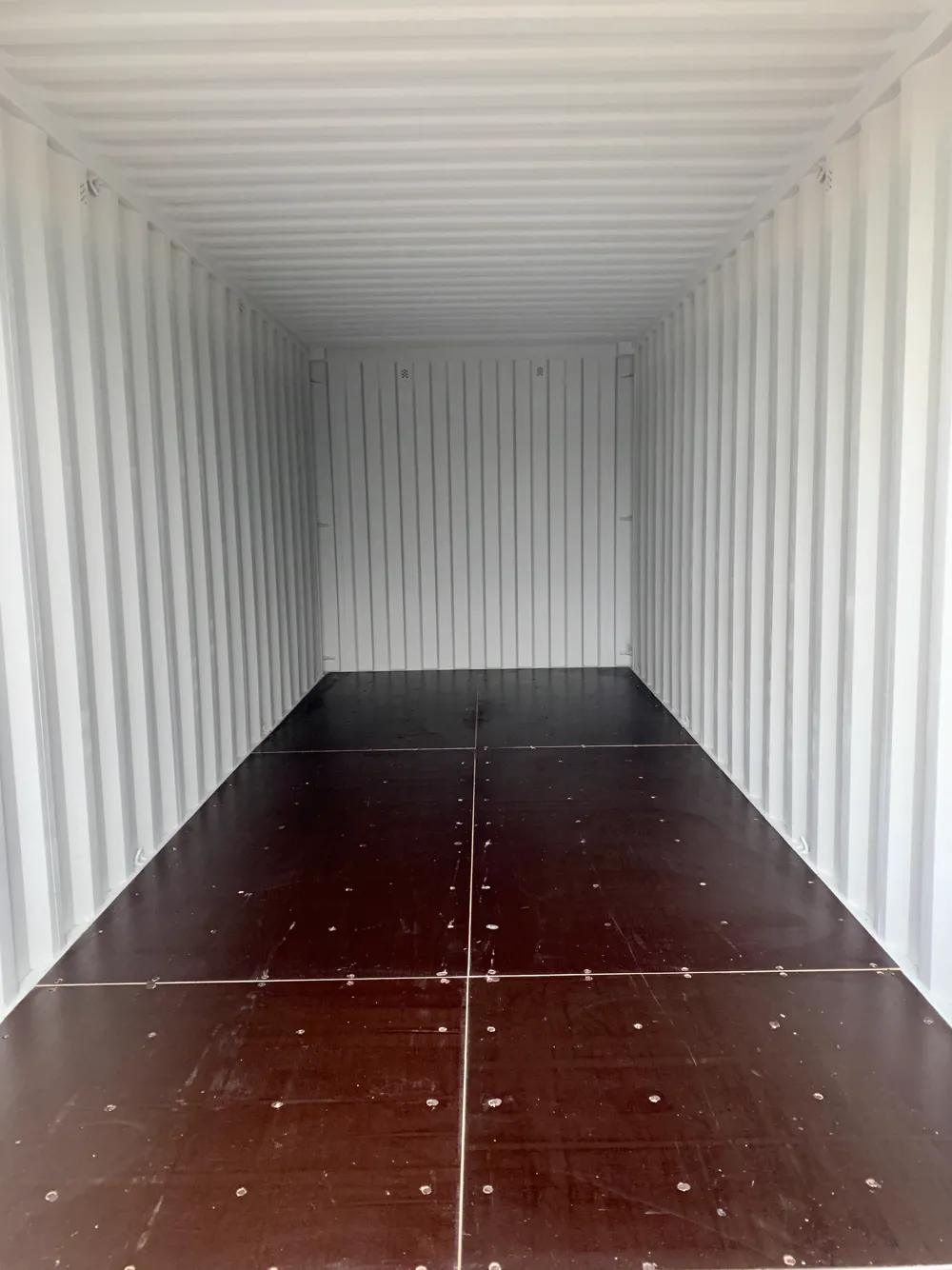 The bright, clean inside of a storage container with a swept timber floor