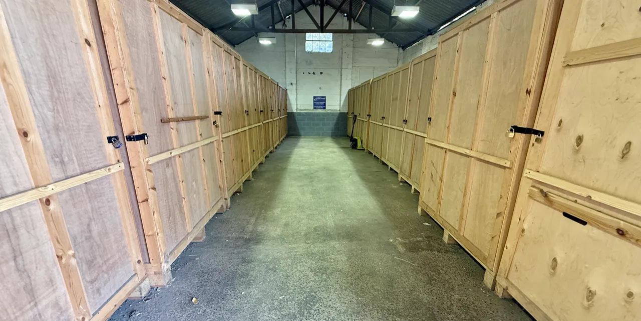 A row of large wooden storage crates inside Perry Storage's covered warehouse